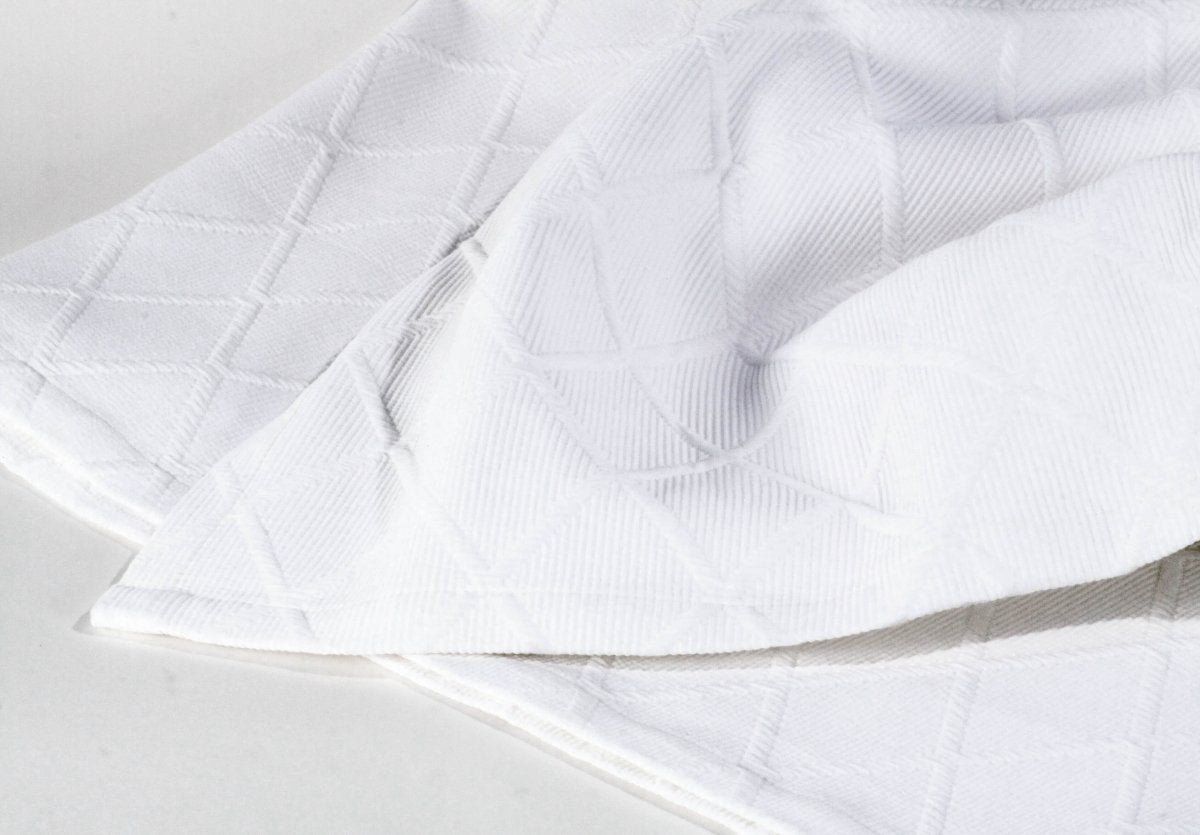 Tagesdecke Vera mit Kissen von Evelyn Kahle – weißer Baumwoll-Überwurf mit Rautenmuster