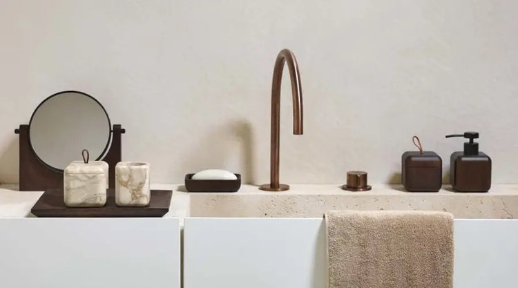 Bad Accessoires Sets mit dunklem Seifenspender, Dosen, Becher in heller Marmoroptik und rundem Spiegel am Waschbecken