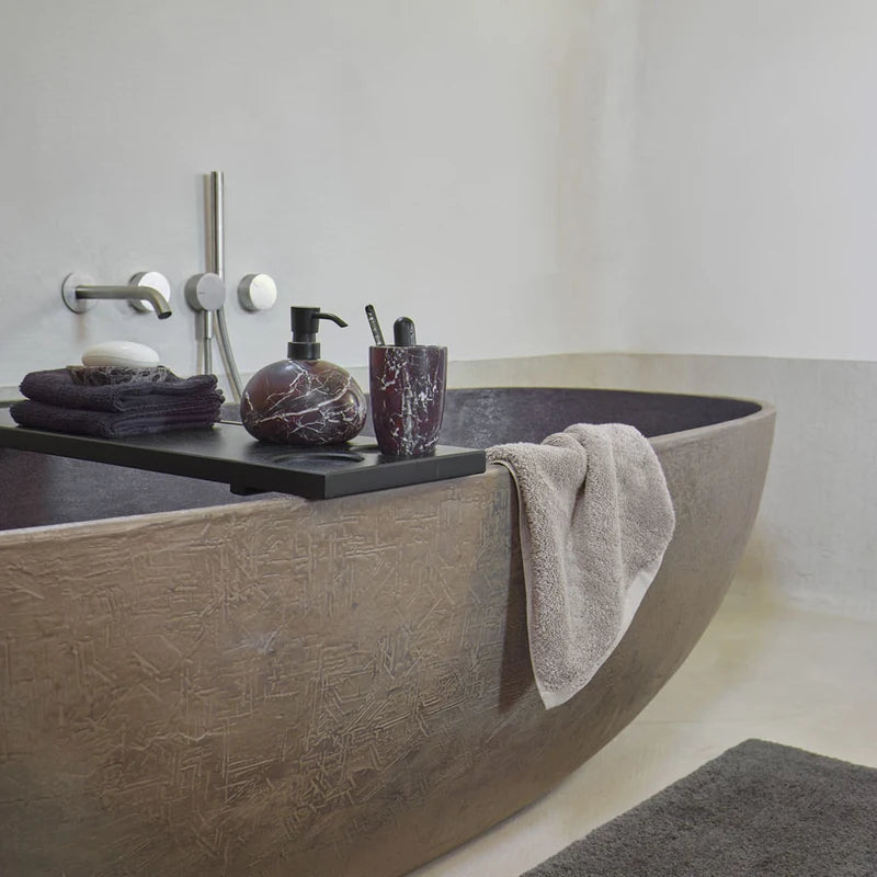 Badewannenbrücke Mink von Aquanova in Schwarz mit dunklen Badaccessoires und Handtüchern auf einer braunen Badewanne
