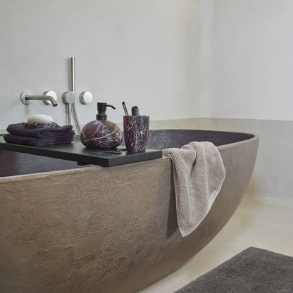 Badewannenbrücke Mink von Aquanova in Schwarz mit dunklen Badaccessoires und Handtüchern auf einer braunen Badewanne
