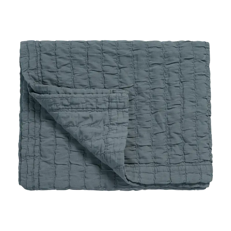 Tagesdecke Vandyck Pure 64 in Blaugrau, 180 × 260 cm, gefaltet mit quadratischer Steppung und umgeschlagener Ecke
