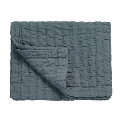 Tagesdecke Vandyck Pure 64 in Blaugrau, 180 × 260 cm, gefaltet mit quadratischer Steppung und umgeschlagener Ecke
