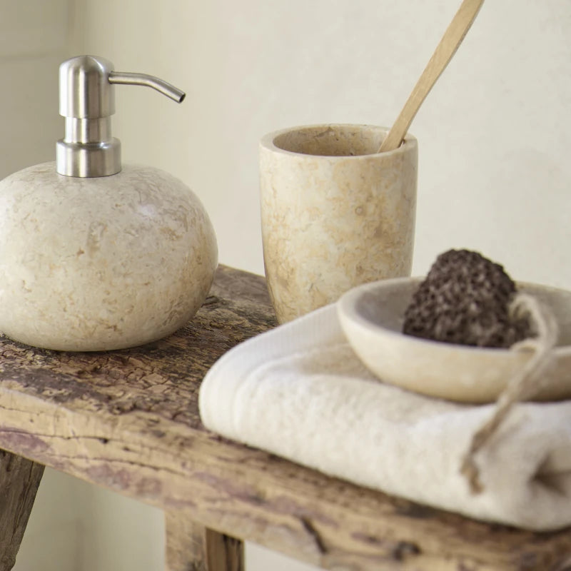 Marmor-Seifenspender und Zahnputzbecher in Almond auf rustikalem Holzhocker mit Handtuch in Creme – warme Erdtöne für kleine Bäder
