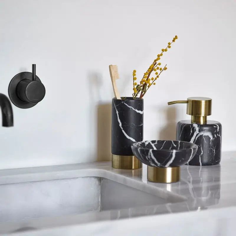 Edle Marmor-Accessoires wie Seifenspender, Ablagen und Becher stilvoll im Badezimmer kombiniert