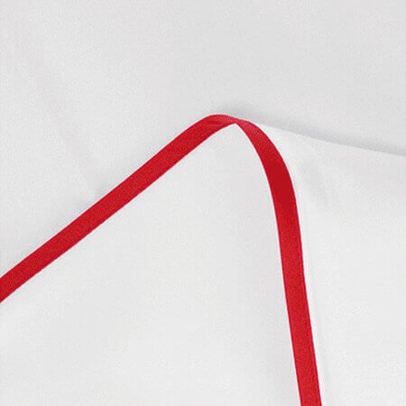 Perkal-Paspel-Bettwäsche von Evelyn Kahle, elegantes Weiß mit roter Satin-Paspel, edles Schlafzimmer mit Farbakzent.