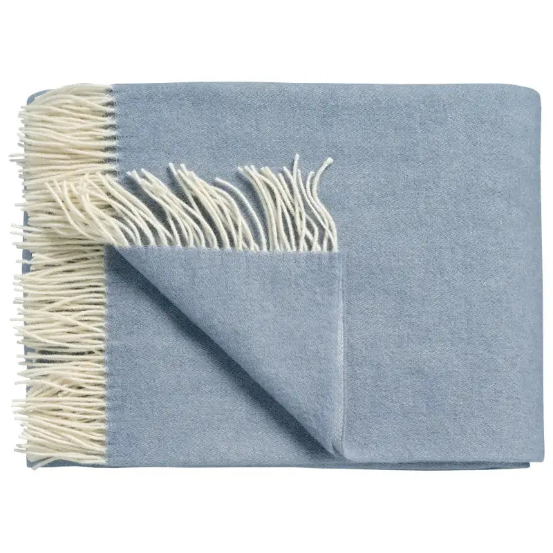 Wolldecke Vandyck Home Bellavita in Dusty Blue, gefaltetes Lammwoll-Plaid mit cremefarbenen Fransen und umgeschlagener Ecke
