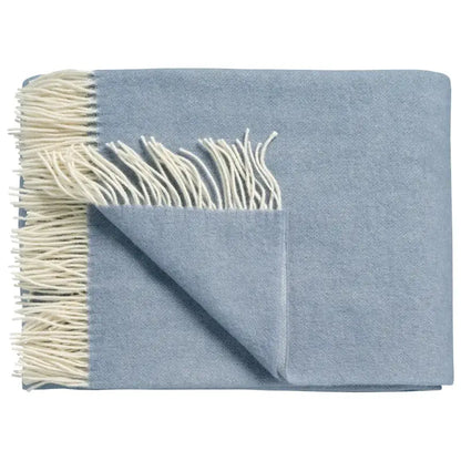Wolldecke Vandyck Home Bellavita in Dusty Blue, gefaltetes Lammwoll-Plaid mit cremefarbenen Fransen und umgeschlagener Ecke
