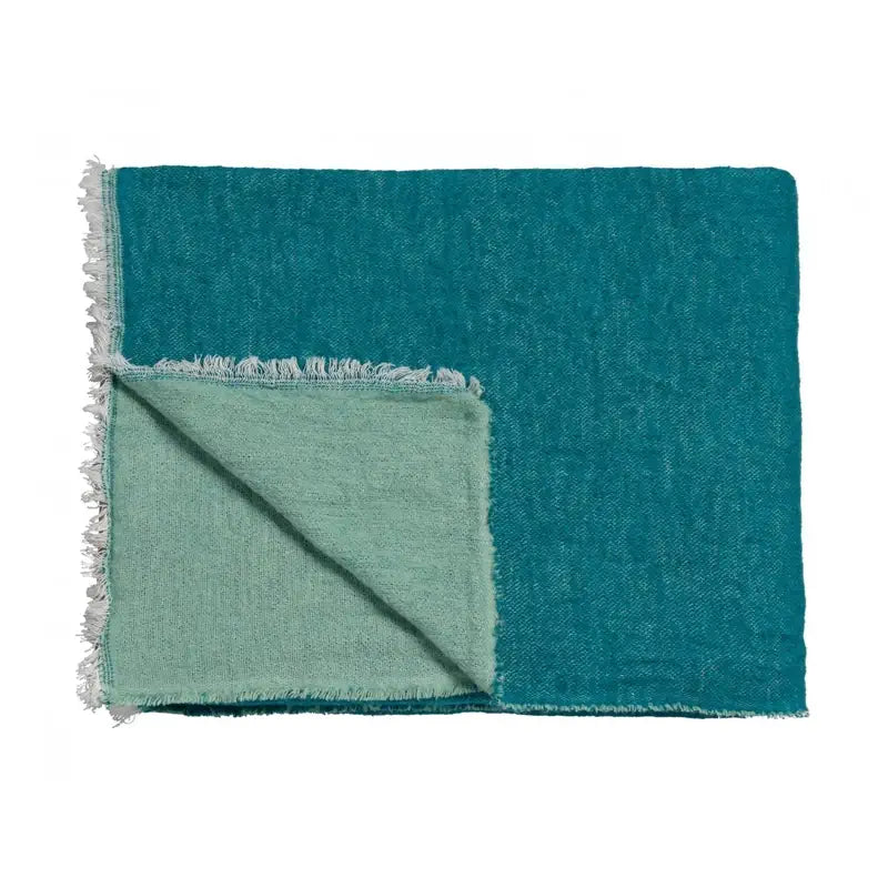 Wohndecke Home 83 in Sea Green, gefaltetes Plaid mit türkisgrüner Vorderseite, hellgrüner Rückseite und hellen Fransen
